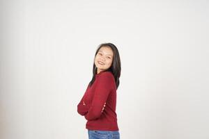 jovem ásia mulher dentro vermelho camiseta cruzado braços e sorridente às Câmera isolado em branco fundo foto