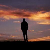 homem silhueta dentro a campo e pôr do sol fundo foto