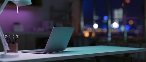 uma computador portátil computador em uma mesa dentro uma moderno Sombrio escritório quarto às noite características escuro roxa néon luzes. foto