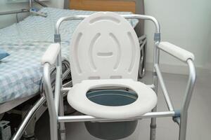 vaso sanitário e cadeira de banho no banheiro para idosos. foto