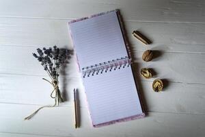 aberto caderno e caneta em uma Área de Trabalho com decoração foto