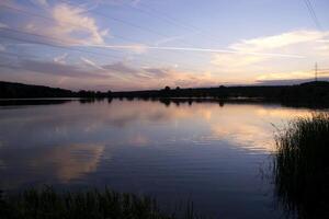 uma lindo pôr do sol às lago. foto