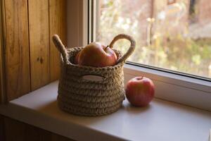 a maçãs dentro cesta em uma janela peitoril. foto