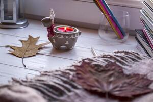 acolhedor Área de Trabalho com livros, vela luz e lindo decorações. foto