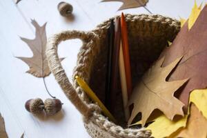 outono folhas dentro uma cesta em a escrivaninha. foto