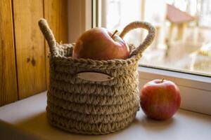 a maçãs dentro cesta em uma janela peitoril. foto