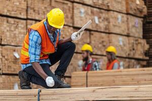 africano trabalhadores homem Engenharia caminhando e inspecionando com trabalhando suíte vestir e mão luva dentro madeira madeira armazém. conceito do inteligente indústria trabalhador operativo. madeira fábricas produzir madeira palato. foto