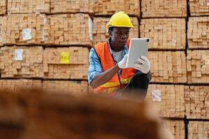 africano trabalhadores homem Engenharia caminhando e inspecionando com trabalhando suíte vestir e mão luva dentro madeira madeira armazém. conceito do inteligente indústria trabalhador operativo. madeira fábricas produzir madeira palato. foto