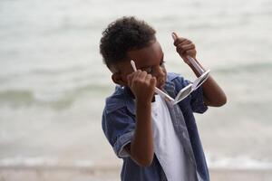 misturado raça africano e ásia Garoto é jogando às a ao ar livre área. sorridente feliz Garoto tem Diversão corrida em a de praia. retrato do Garoto estilo de vida com uma único Penteado. foto