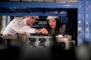 técnico engenheiros equipe verificação a máquina e manutenção serviço. trabalhadores olhando às poupar partes dentro estoque às armazém fábrica. trabalhador com uma lista de controle olhando em parte do máquina peças. foto