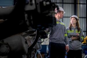 engenheiros Verifica ao controle pesado máquina robô braço. diverso equipe do industrial robótica engenheiros colhido por aí máquina. profissional maquinaria operadores reparar elétrico robô em brilhante digital painel. foto