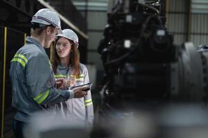 engenheiros Verifica ao controle pesado máquina robô braço. diverso equipe do industrial robótica engenheiros colhido por aí máquina. profissional maquinaria operadores reparar elétrico robô em brilhante digital painel. foto