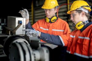 masculino engenheiro trabalhadores manutenção automático robótico braço máquina dentro uma fábrica. trabalhador verificação e reparação automático robô mão máquina. técnico trabalhador Verifica para reparar fábrica máquina. foto