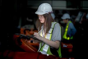 o negócio engenheiros encontro e verificação Novo máquina robô. trabalhadores caminhando às armazém indústria Soldagem máquina. o negócio negociação conceitos e tecnologia. mulheres usando inteligente tábua para presente cara. foto