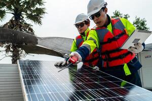 engenheiro homens inspecionar módulos do fotovoltaico célula painéis. industrial renovável energia do verde poder. trabalhadores preparar materiais antes construção em local com a pilha do painéis às fundo. foto