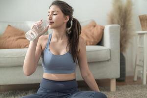 fechar acima do jovem face caucasiano ginástica mulher vestindo esporte roupas Treinamento interior bebendo fresco água. saudável estilo de vida e bem-estar. foto