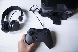 virtual realidade copos, controle de video game e fones de ouvido em uma branco fundo. foto