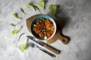 a tigela do orgânico salada e talheres em uma mesa. foto