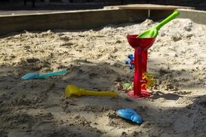 a plástico brinquedos dentro a caixa de areia, ar livre. foto