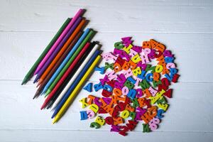 multicolorido cartas e conjunto do lápis em a mesa. colorida de madeira alfabeto e lápis em uma mesa. foto