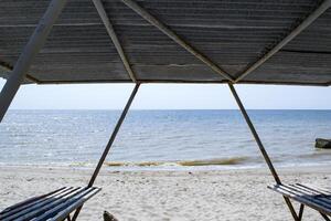 uma caramanchão com bancos em a de praia. lindo seascape. a Lugar, colocar para descansar. foto