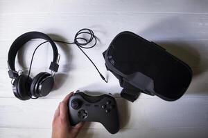 virtual realidade copos, controle de video game e fones de ouvido em uma branco fundo. foto