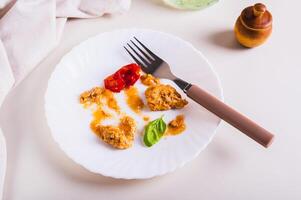 Comida desperdício e talheres em uma sujo prato em a mesa foto