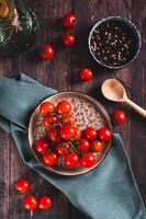 prato com fresco cereja tomates em uma de madeira mesa topo e vertical Visão foto