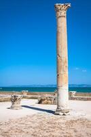 antigo ruínas às Cartago, Tunísia com a Mediterrâneo mar dentro a fundo foto