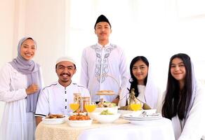 eid Mubarak muçulmano família tendo iftar jantar comendo tradicional Comida foto