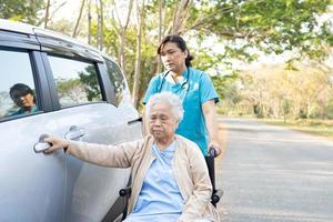 paciente asiático sênior ou idosa senhora sentada na cadeira de rodas preparar chegar ao carro dela, conceito médico forte saudável. foto