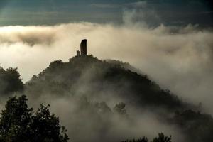 castelo envolto em nevoeiro matinal em um dia de outono na itália foto