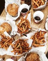 topo Visão do saboroso francês fritas, Hamburger e Cola em de madeira mesa foto