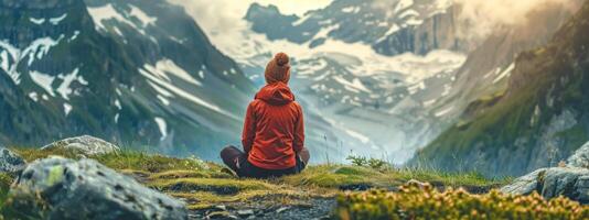 ai gerado pessoa dentro vermelho Jaqueta meditando no meio majestoso montanhas foto