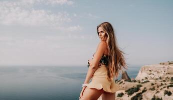 mulher viagem mar. feliz turista levando cenário ao ar livre para recordações. mulher viajante parece às a Beira do a penhasco em a mar baía do montanhas, partilha viagem aventura viagem foto