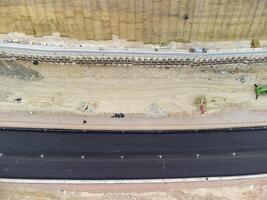 montanha estrada contração. trabalhadores reforçar a declive sobre a Novo estrada. estrada construção dentro progresso em declive natureza canyon. a infraestrutura desenvolvimento e logística. aéreo zangão tiro foto