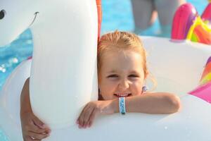 pequeno fofa menina dentro natação piscina com inflável brinquedo foto