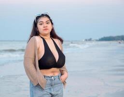 retrato jovem ásia mulher gordo gordo fofa lindo sorrir feliz Diversão apreciar relaxar bikini roupa de banho corpo sexy frente Visão mar de praia branco areia limpar \ limpo céu azul calma natureza oceano onda água viagem em feriado foto