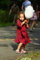 feliz criança pequena menina comendo algodão doce foto