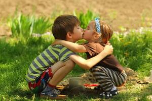crianças se beijando e abraçando dentro a jardim, lado Visão foto