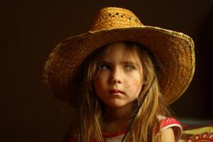 retrato do uma caucasiano criança pequena menina vestindo uma Palha chapéu foto