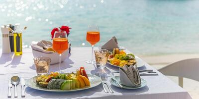 café da manhã fresco em um belo local com vista para o mar. férias de verão de luxo ou destino de lua de mel. mesa com comida deliciosa gourmet perto do mar com horizonte. belo cenário de café da manhã de verão foto