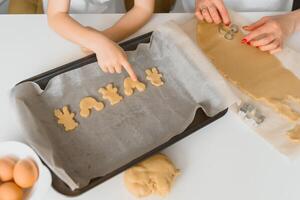 jovem mãe e filho dentro cozinha fazer biscoitos. foto