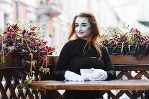 mímica comediante bebendo café. menina mímica bebidas café dentro Paris. foto