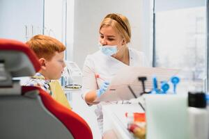 Garoto satisfeito com a serviço dentro a dental escritório. conceito do pediatra dental tratamento foto