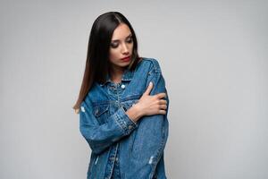 lindo caucasiano menina dentro uma jeans Jaqueta posando dentro a estúdio em uma branco fundo. foto