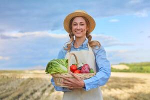 mulher agricultor Palha chapéu avental em pé terras agrícolas sorridente fêmea agrônomo especialista agricultura agronegócio feliz positivo caucasiano trabalhador agrícola campo foto