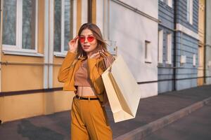 1 jovem caucasiano europeu menina viciado em compras caminhando ao longo a rua com compras dentro pacotes. foto