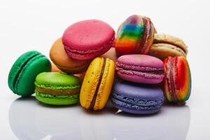 sortido multicolorido macarons empilhado e arranjado em branco superfície com reflexão foto