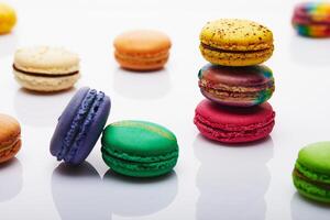 multicolorido empilhado e separado macarons exibido em branco fundo com reflexão foto